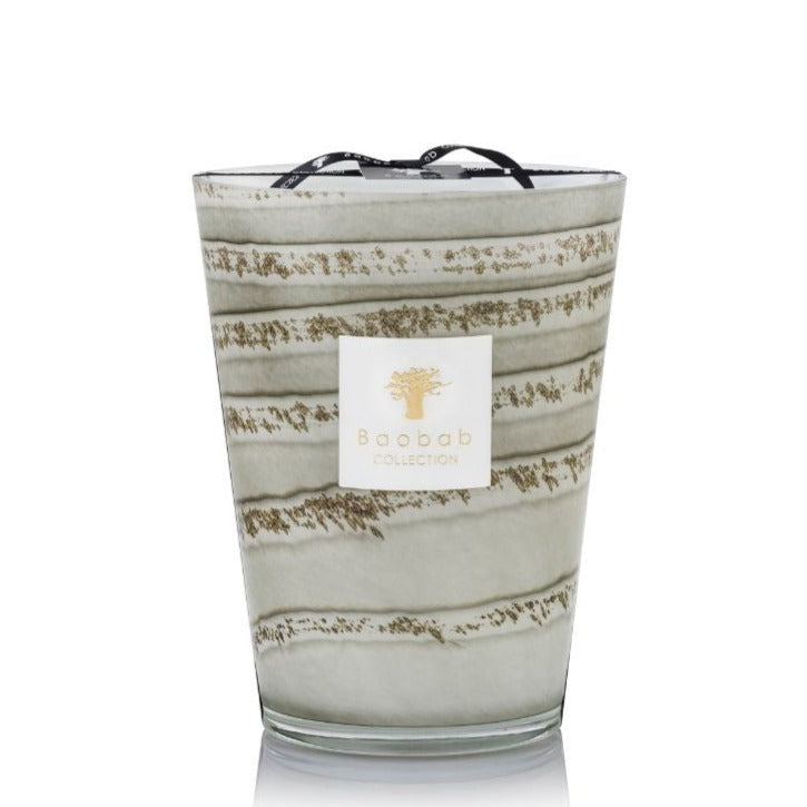 A Baobab Collection Sand Atacama Candle, featuring a decorative glass holder with green and gold stripes, and Atacama scented, isolated on a white background.