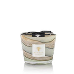 A Baobab Collection Sand Sonora Candle with patchouli in a marbled glass container with the brand's logo on a label, isolated on a white background.