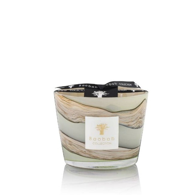 A Baobab Collection Sand Sonora Candle with patchouli in a marbled glass container with the brand's logo on a label, isolated on a white background.