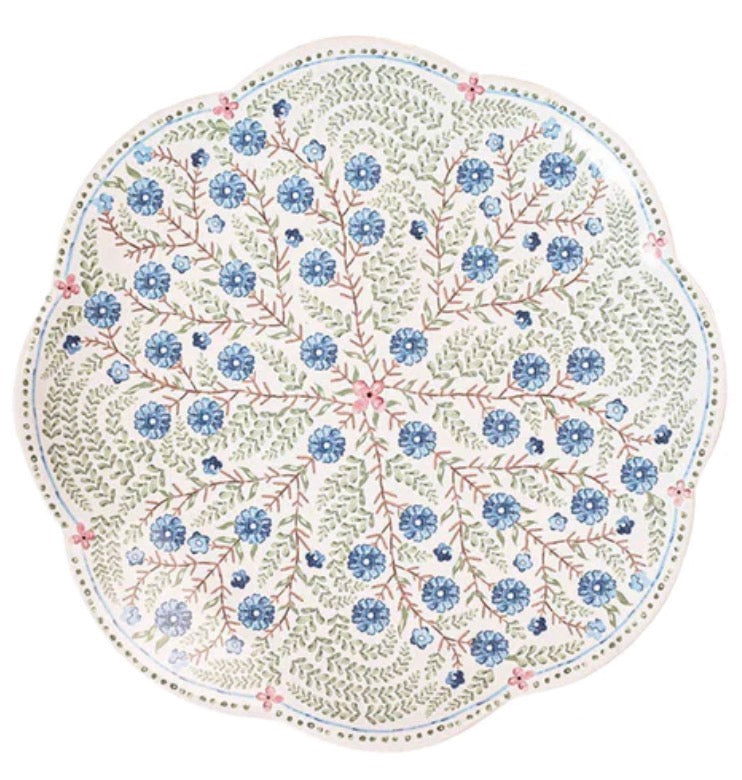 The Juliska Villa Seville Chambray Dinnerware Collection features a round scalloped plate with blue florals and green leaves on white, ideal for adding classic floral charm to your table.