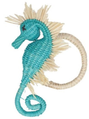 The Sea Horse Napkin Ring Collection by Mercedes Salazar features seahorse-shaped, artisan-made napkin rings crafted with blue and beige straw-like material and a circular loop, adding a coastal touch to your table.
