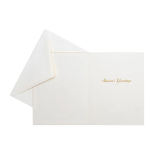 The Caspari Magnolia Bloom Boxed Card Set features elegant white cards with gold "Season's Greetings" text and matching envelopes—ideal for Christmas or holiday cards.