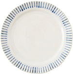 A white ceramic plate from Juliska's Sitio Stripe Delft Blue Dinnerware Collection displays a scalloped edge and radiant blue rim stripes, seen from above.