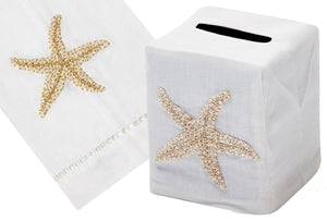 The Haute Home Starfish Bath Collection features a cream-on-white Italian linen tissue box cover and hand towel adorned with an exquisite hand-embroidered starfish design.