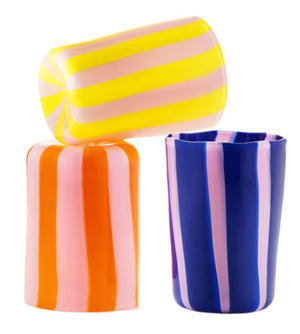 The Aquazzura Casa Murano Dolcevita Stripe Tumbler Collection features three vibrant, handblown tumblers—yellow/pink, orange/pink, and blue/pink—artfully arranged on a white background to highlight Murano glass-inspired craftsmanship.