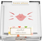 The Kiss Gift Enclosure Set by Karen Adams features hand-glittered cards with a pink glittery lip print, packaged in a clear box labeled "sealed with a kiss" above an envelope, perfect for charming gift enclosures.