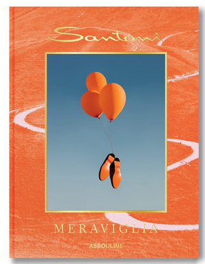 Orange shoes tied to three matching balloons float against a blue sky on the cover of “Santoni Meraviglia” by Assouline, celebrating Italian craftsmanship and artisanal excellence.