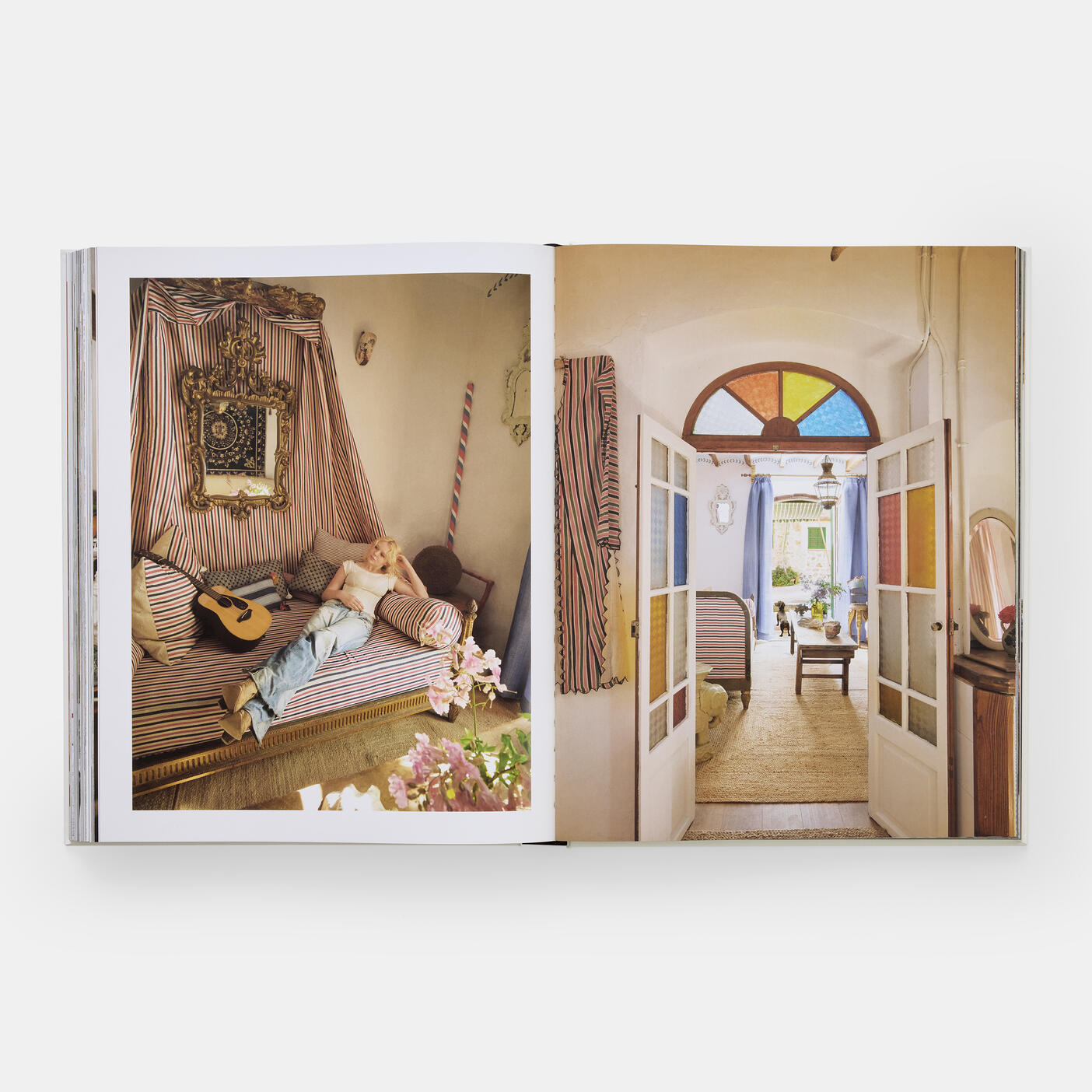 An open book from Phaidon's "FREDERIC: The Last Word in Chic" reveals a vibrant interior scene with a person lounging on a striped sofa and a guitar, evoking popular interiors photography styles with elements like a colorful doorway reminiscent of those featured in Frederic magazine.