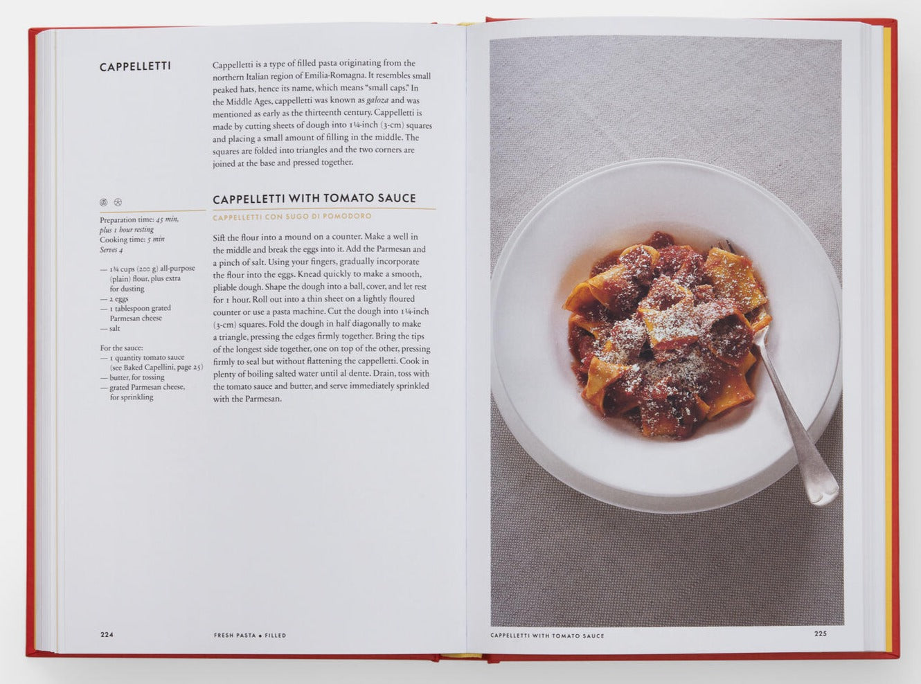 Open the *Silver Spoon Pasta: Authentic Italian Recipes* cookbook by Phaidon, featuring a recipe for "Cappelletti with Tomato Sauce" on the left page and a photo of the dish on the right. The spread highlights Italian cuisine, presenting pasta topped with rich tomato sauce and grated cheese.