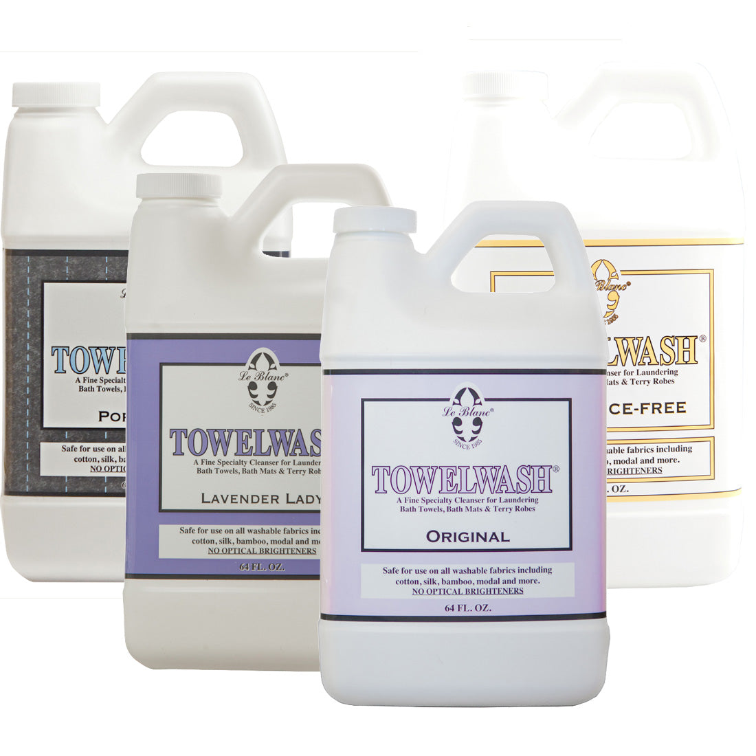 Four large Le Blanc Towel Wash bottles in assorted scents are displayed side by side, highlighting their labels—ideal for keeping your absorbent towels and organic fabrics fresh and clean.