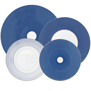 Four Tresor Blue Dinnerware Collection porcelain plates by Raynaud, featuring blue and white geometric patterns, are arranged overlapping on a white background.