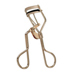 The Tweezerman Curl 38 Eyelash Curler is a gold metal curler with black rubber padding, designed to enhance almond-shaped eyes, shown against a white background.