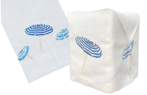 A hand-embroidered, white Italian linen tissue box cover and napkin featuring blue and white striped beach umbrellas from the Haute Home Beach Umbrella Bath Collection.