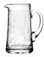 The William Yeoward Crystal Fern Jug is a clear glass pitcher with a handle, featuring delicate fern and botanical designs etched along the sides and base—a charming companion to your favorite stemware.