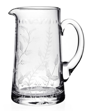 The William Yeoward Crystal Fern Jug is a clear glass pitcher with a handle, featuring delicate fern and botanical designs etched along the sides and base—a charming companion to your favorite stemware.
