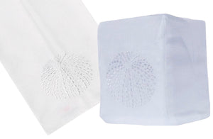 Two white embossed paper towels from the Sea Urchin Bath Collection by Haute Home, with patterns resembling hand-embroidery. One is laid flat, and the other is folded into a cube shape, mimicking a charming tissue box cover.