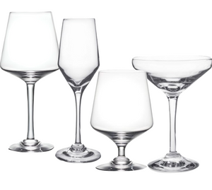 Four empty glasses from the Simon Pearce Vintner Drinkware Collection—a red wine glass, handmade flute, white wine glass, and coupe—stand elegantly on a white background, reflecting Napa Valley winemaker style.