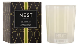 The Nest Grapefruit Candle Collection features a refreshing fragrance and comes in a frosted glass holder beside its signature black and gold patterned box.