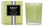 A green Nest Lime Zest & Matcha Candle Collection candle and its box sit side by side, offering an energizing boost with their invigorating scent.