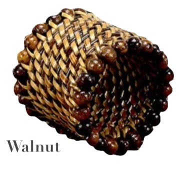 The Calaisio Woven Napkin Ring is handmade by artisans from walnut-colored water-vines and features dark and light wooden beads around the edge. "Walnut" appears in the lower left corner.