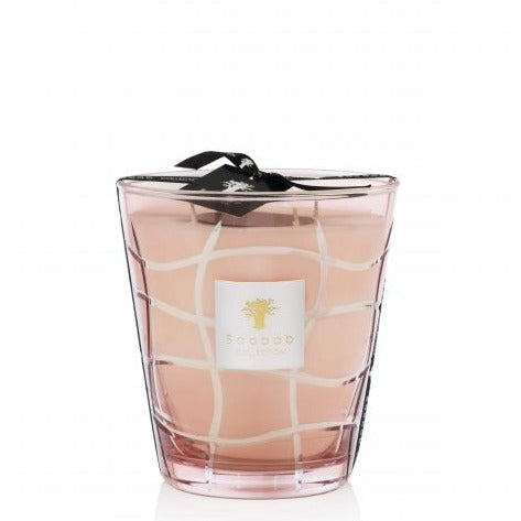 A Baobab Waves Malibu Candle in a clear glass holder with a decorative web pattern and a black ribbon, infused with a floral perfume.