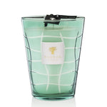 A Baobab Waves Nazare candle in a teal, grid-patterned glass container with a white label featuring a golden lemon tree wood logo.