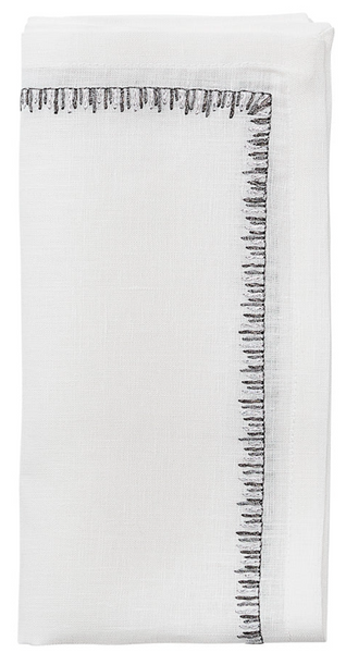 A white linen handkerchief with embroidered black stitching, like the Kim Seybert Filament Napkin.