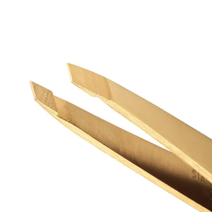 Close-up of the Tweezerman Ultra Precision Gold Slant Tweezer, featuring angled tips ideal for brow shaping, shown against a white background.