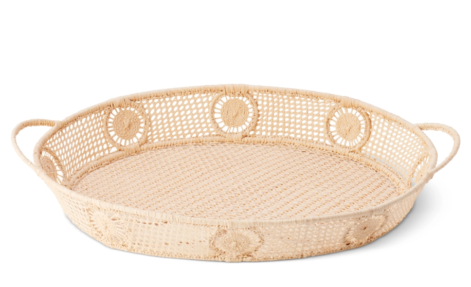 The Aerin Raffia Round Tray features open lattice sides, circular patterns, and dual handles. This decorative accent adds coastal style to any space and is beautifully showcased against a white background.