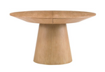 The Discus Extendable Dining Table by Sherrill/Mr & Mrs Howard features a wide, flat round top and a thick, tapered cylindrical natural wood base, shown against a white background for a modern look.