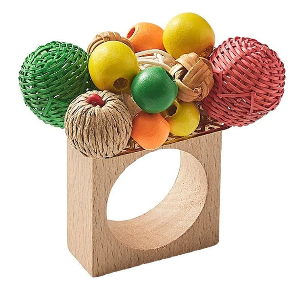 Kim Seybert Java Napkin Ring with a circular hole holding an assortment of colorful handmade rattan balls and spheres.