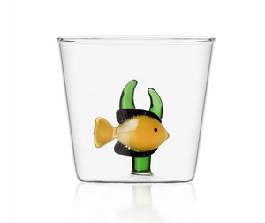 Part of the Marine Garden Drinkware Collection by Ichendorf Milano, this clear glass tumbler features a handmade yellow and black fish with green seaweed at the base—a signature piece of artistic charm.