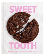 A large chocolate cookie with sea salt and gooey chocolate pieces, broken on parchment, sets a nostalgic dessert mood. "Sweet Tooth: 100 Desserts to Save Room For" by Penguin Random House pops in playful pink text above and below.