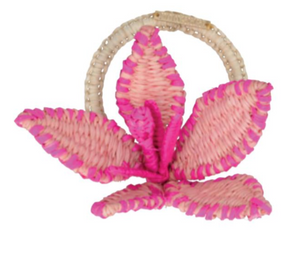 The Mercedes Salazar Flower Napkin Ring features three large petals crafted from woven pink and beige raffia with a circular handle—perfect as a decorative accent for summer gatherings.