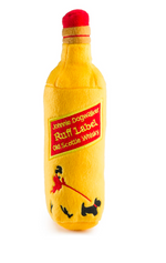 The Johnnie Dogwalker Ruff Label Dog Toy by Haute Diggity Dog is a yellow, bottle-shaped toy with a red cap from the Muttini Bar collection, labeled “Ruff Label Old Scottish Whisky,” and features a graphic of a person walking a dog.