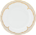 The Golden Elegance Dinner Plate by Herend features a white porcelain body with scalloped edges, intricate hand painted designs, and gold trim on the rim; its plain center evokes classic Herend craftsmanship.