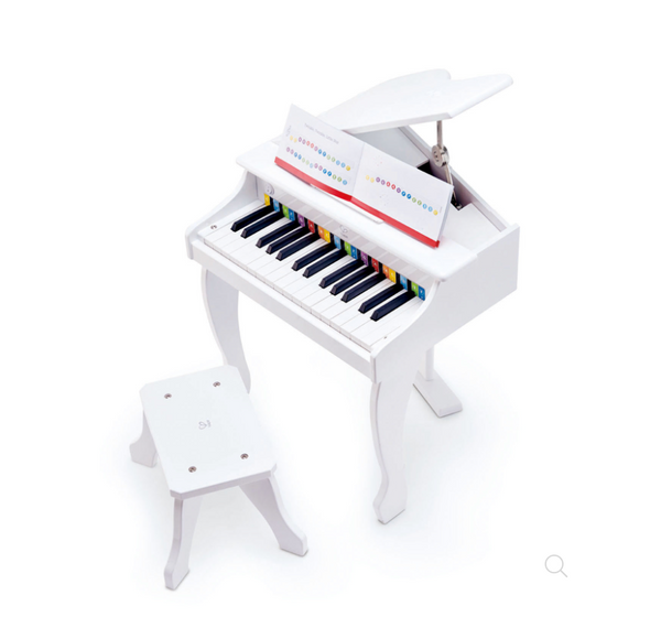 Miniature white Hape Deluxe White Grand Piano with a music note sheet on a white background.