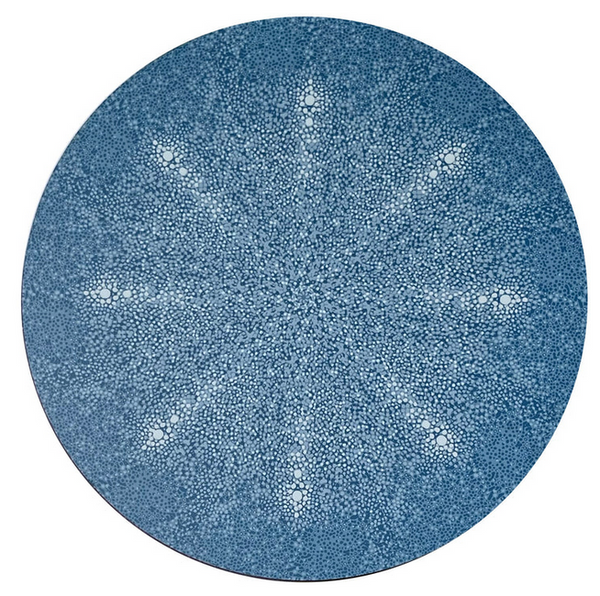A blue circle with Tisch NY's Shagreen Placemat Collection design and white dots on it.