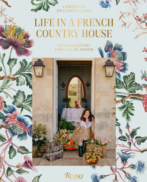 A child standing at the entrance of a house adorned with floral decorations and a title above about Life in a French Country House, showcasing stylish hospitality by Common Ground.