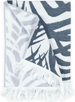 The Matouk Zebra Palm Beach Towel in navy features a folded, fringed design with zebra-like patterns, ideal for adding an exotic and sophisticated touch as either a towel or a stylish accent piece.