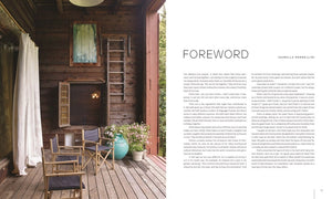 A cozy wooden porch with chairs and a potted plant is featured next to the "Foreword" by Isabella Rossellini in "Pietro Cicognani: Architecture and Design" by Common Ground, highlighting custom architecture.