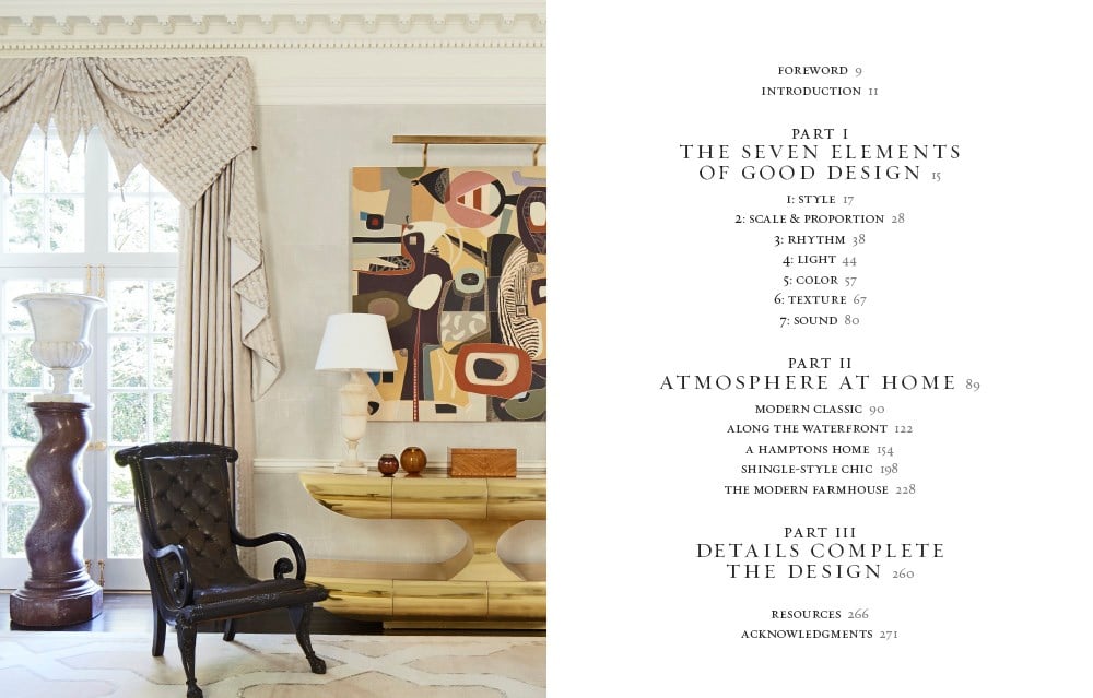 A room features a tall chair and a curtain on the left, with a modern abstract painting on the right. The table of contents from "Atmosphere: The Seven Elements of Great Design" by Common Ground is displayed on the white wall, detailing parts about great design elements and home atmosphere, creating an evocative ambiance.