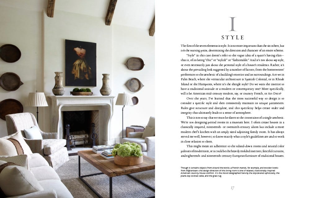 Stylish living room with a light color palette, featuring a fireplace, a central wooden coffee table adorned with greenery, and framed pictures on the wall. The text on the right side discusses "Atmosphere: The Seven Elements of Great Design" by Common Ground and its contribution to creating an evocative atmosphere.