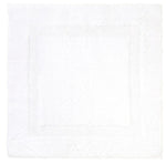 The Aquilon Blanc Bathmat Collection by Yves Delorme features a plain white square bath mat made from 100% cotton with a subtle textured border pattern.