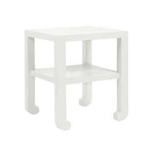 A modern white Askel Side Table from Made Goods with a textured Pristine Faux Raffia shelf on top.