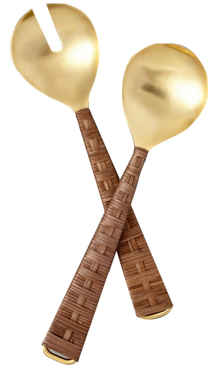 The Ananta Serving Set by Be Home is a handcrafted 2-piece set from India, featuring gold-toned serving utensils with woven brown handles—one slotted spoon and one solid spoon—displayed on a white background.