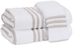 Two white towels from the Matouk Beach Road Collection, Tan Stripe, crafted from luxurious Cairo long-staple cotton terry and accented with beige stripe tape, are stacked neatly on top of each other.