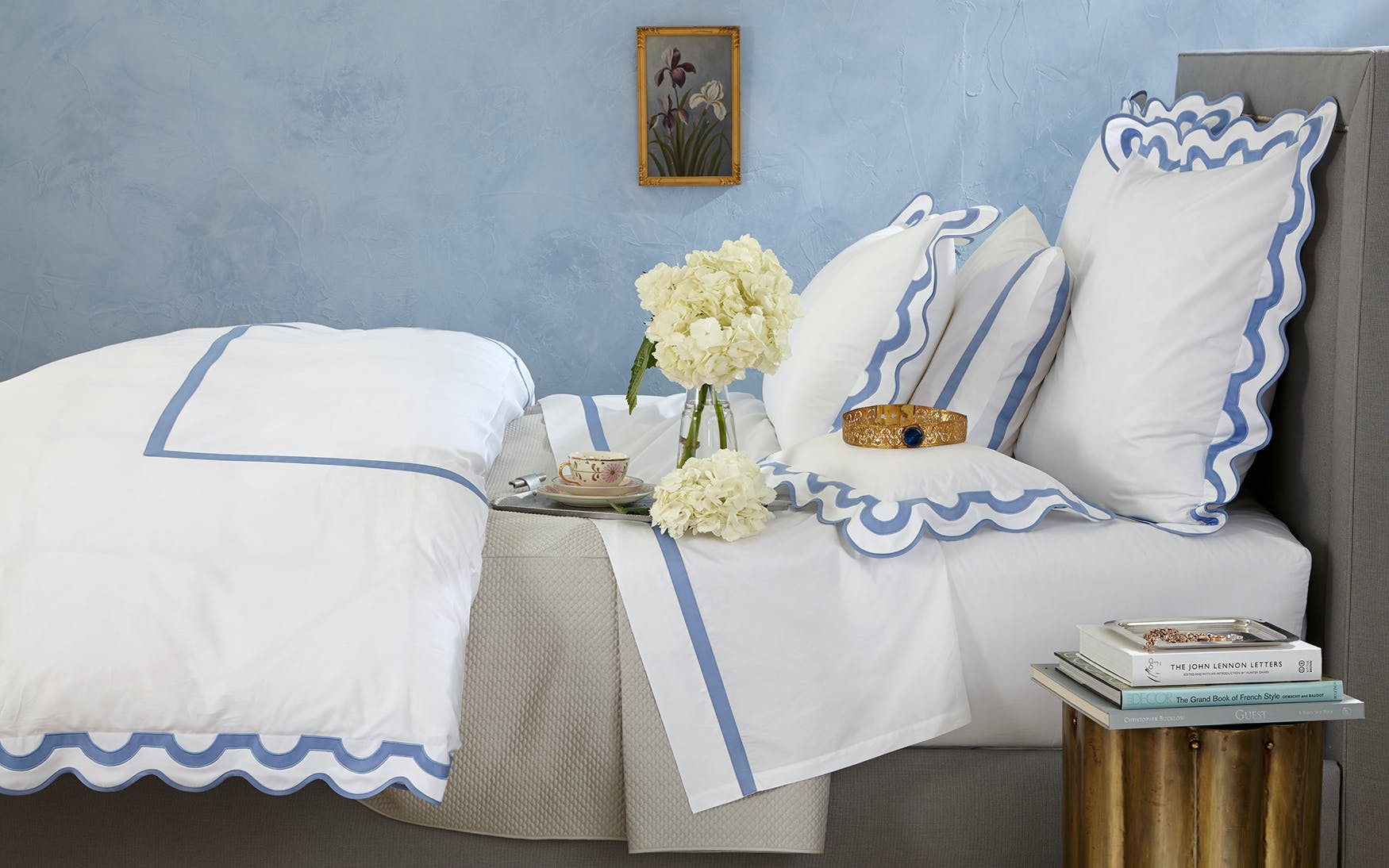 A bed with Matouk Mirasol Bedding Collection, Bone bedding and pillows from Matouk.