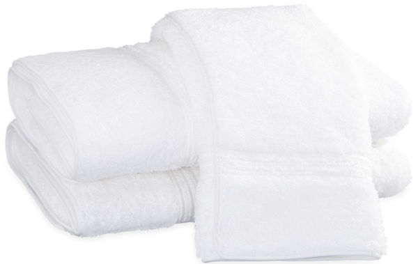 Three Matouk Bel Tempo Bath Collection - White towels stacked on top of each other are made from long-staple cotton.