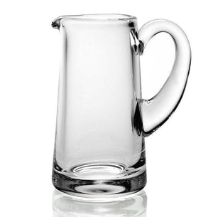 The William Yeoward Crystal Clear Classic Cream Jug is a handmade glass pitcher with a wide base, narrow spout, and large curved handle, ideal for serving berries and cream. Shown here against a plain white background.